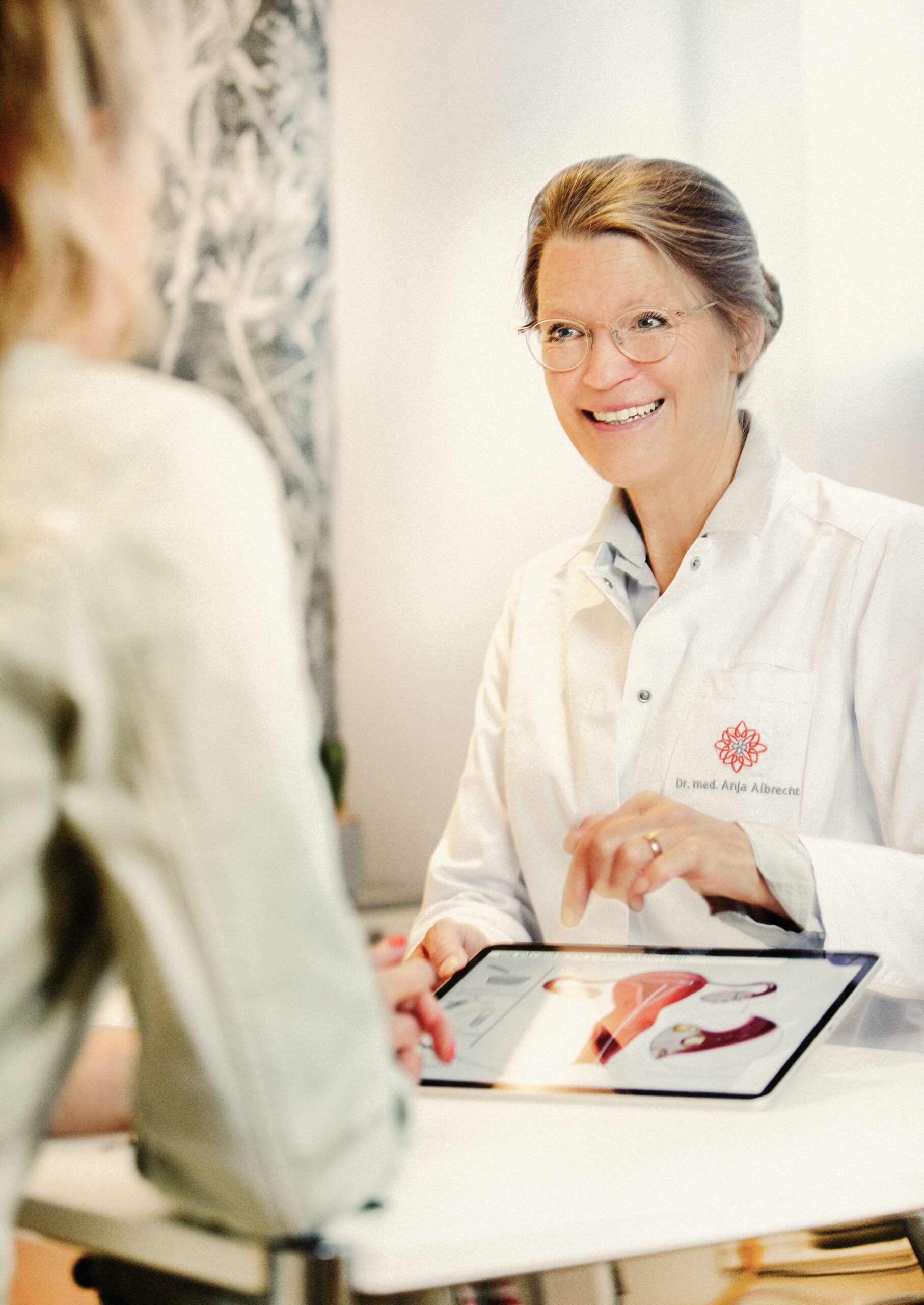 Dr. med. Anja Albrecht im Kinderwunschzentrum in München erklärt die Therapieplanung anhand einer Grafik in einem persönlichen Beratungsgespräch.