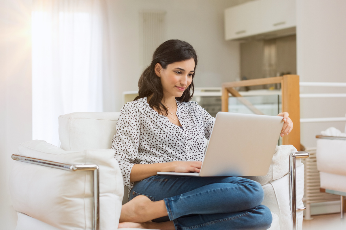 Frau recherchiert auf Ihren Sofa im Internet über die Eileiterdurchgängigkeitsprüfung